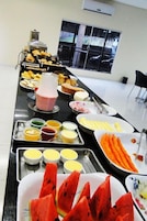 Uma mesa de buffet com diversos alimentos e acompanhamentos.