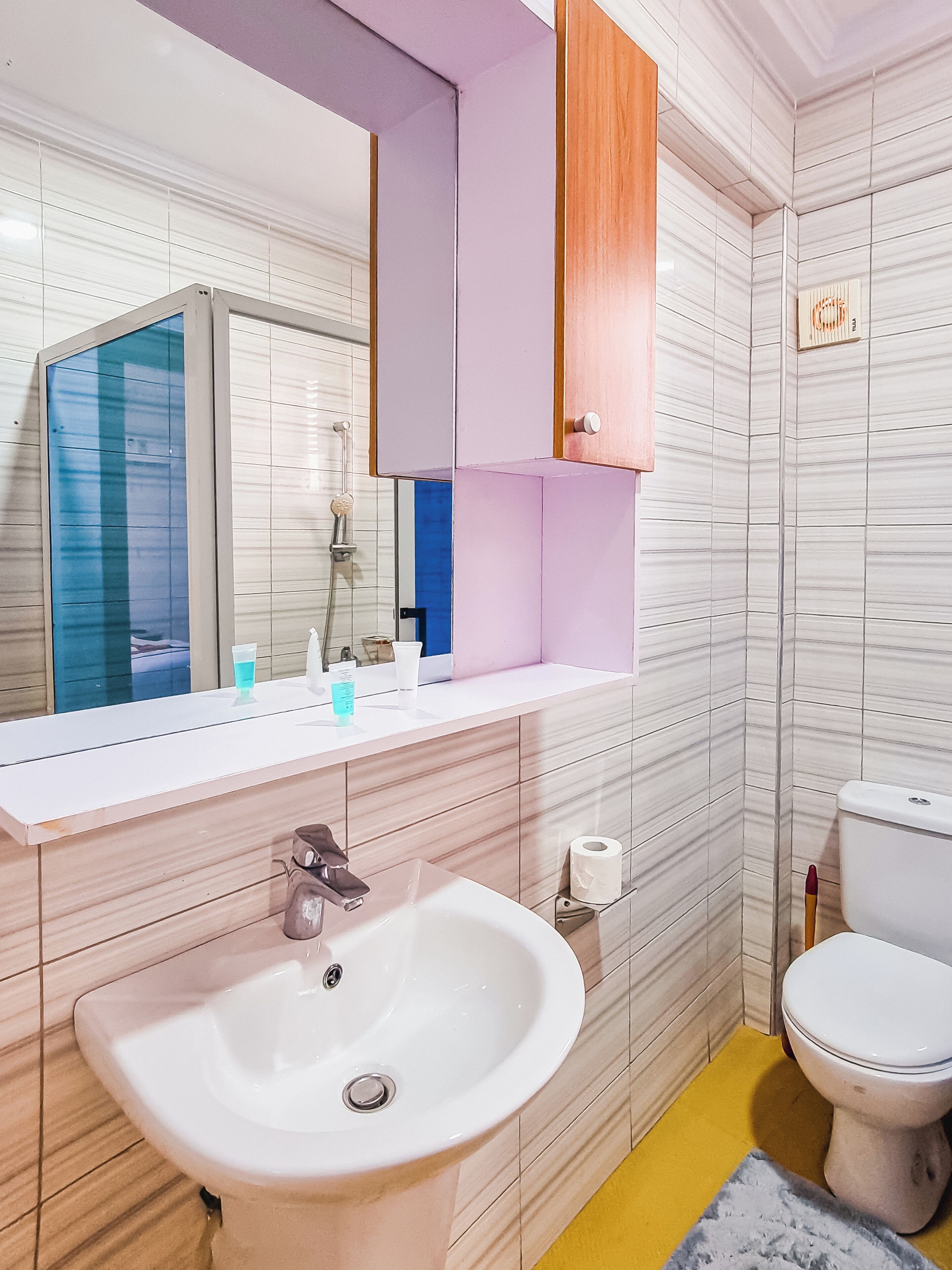 A bathroom with a white sink, a toilet, and a mirror above the sink.