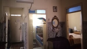 A room with a bed, a mirror, and a door leading to another room. - Chez Simo un petit coin de relax (Safi)