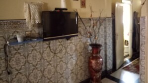 A bathroom with a patterned wall, a towel rack, a mirror, and a sink. - Chez Simo un petit coin de relax (Safi)
