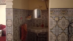 A bathroom with ornate tile patterns, a sink, and a mirror. - Chez Simo un petit coin de relax (Safi)