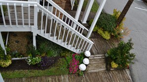 Una escalera de madera con barandillas blancas que lleva a un edificio de ladrillo.