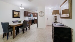 A modern kitchen with dark wooden cabinets, a microwave, and a clock on the wall. - Sage Suite II - Safe, Cozy & Pet Friendly. (San Antonio)