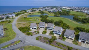 Vue aérienne d’un quartier résidentiel avec des maisons, des routes et un terrain de golf.