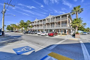 A beachfront hotel with a multi-story structure, a covered outdoor seating area, and a parking lot with cars. - Resort Condo w/ Beach Access on Anna Maria Island! (Bradenton Beach)