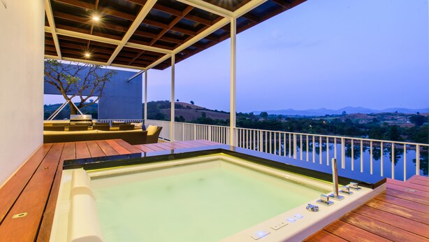 Un jacuzzi en una terraza de madera con vista al paisaje.