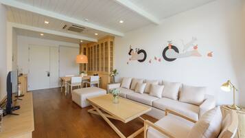 Una sala de estar moderna con un sofá, una mesa de centro y una zona de comedor con sillas y una mesa.