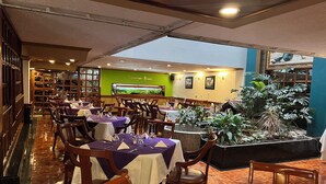 Un restaurante con mesas dispuestas para comer, un gran acuario y diversas plantas.