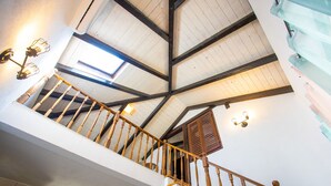 A wooden staircase with a high ceiling and exposed beams. - Family house Futura  (Milna)
