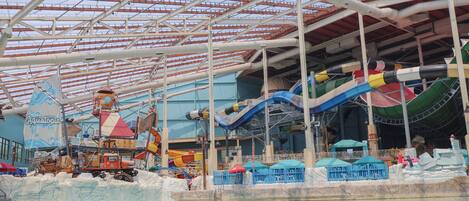 An indoor water park with slides, a boat ride, and a pool area.