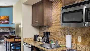 A modern kitchen with granite countertops, stainless steel appliances, and wooden cabinets.