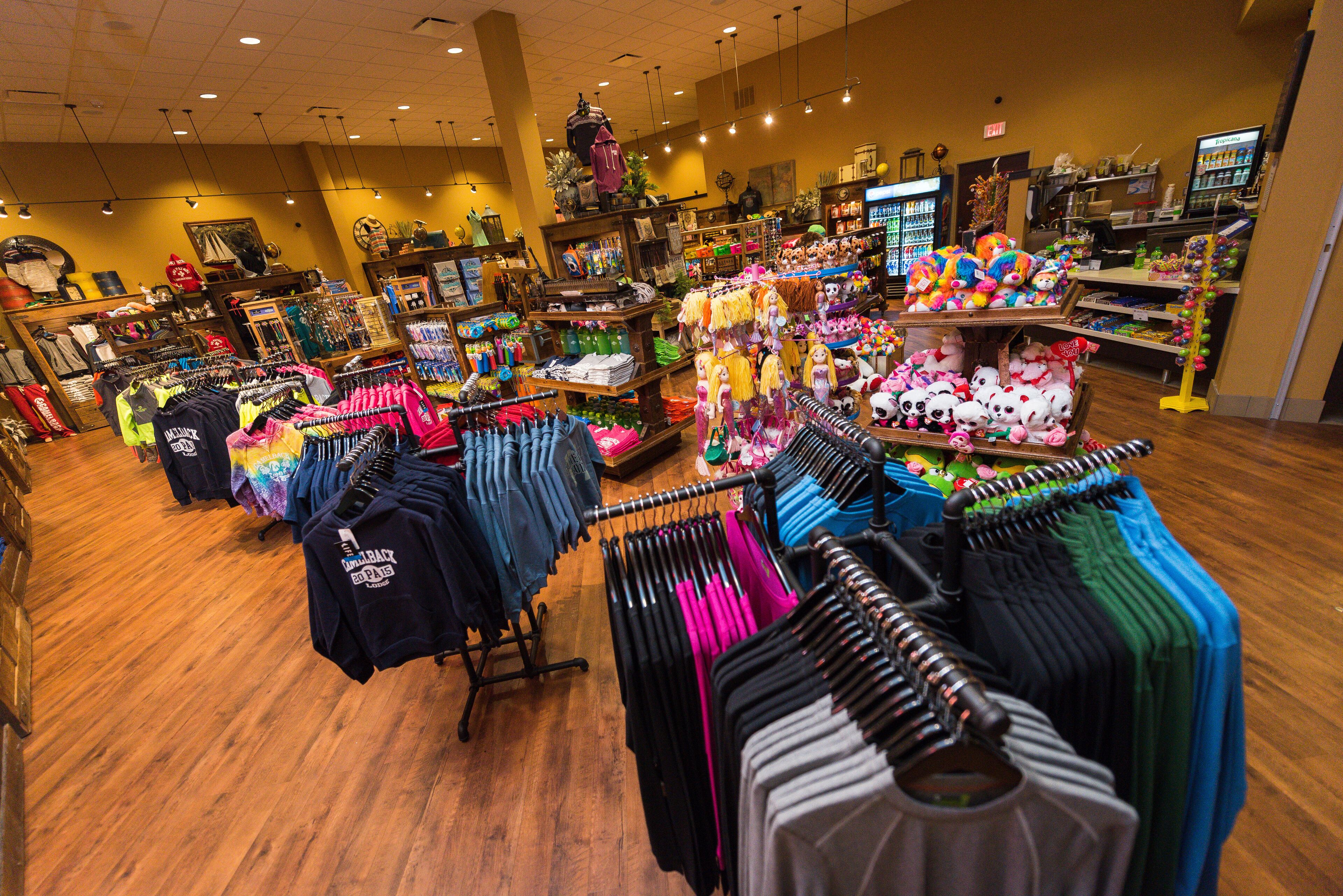 A clothing store with racks of clothes and shelves of merchandise.