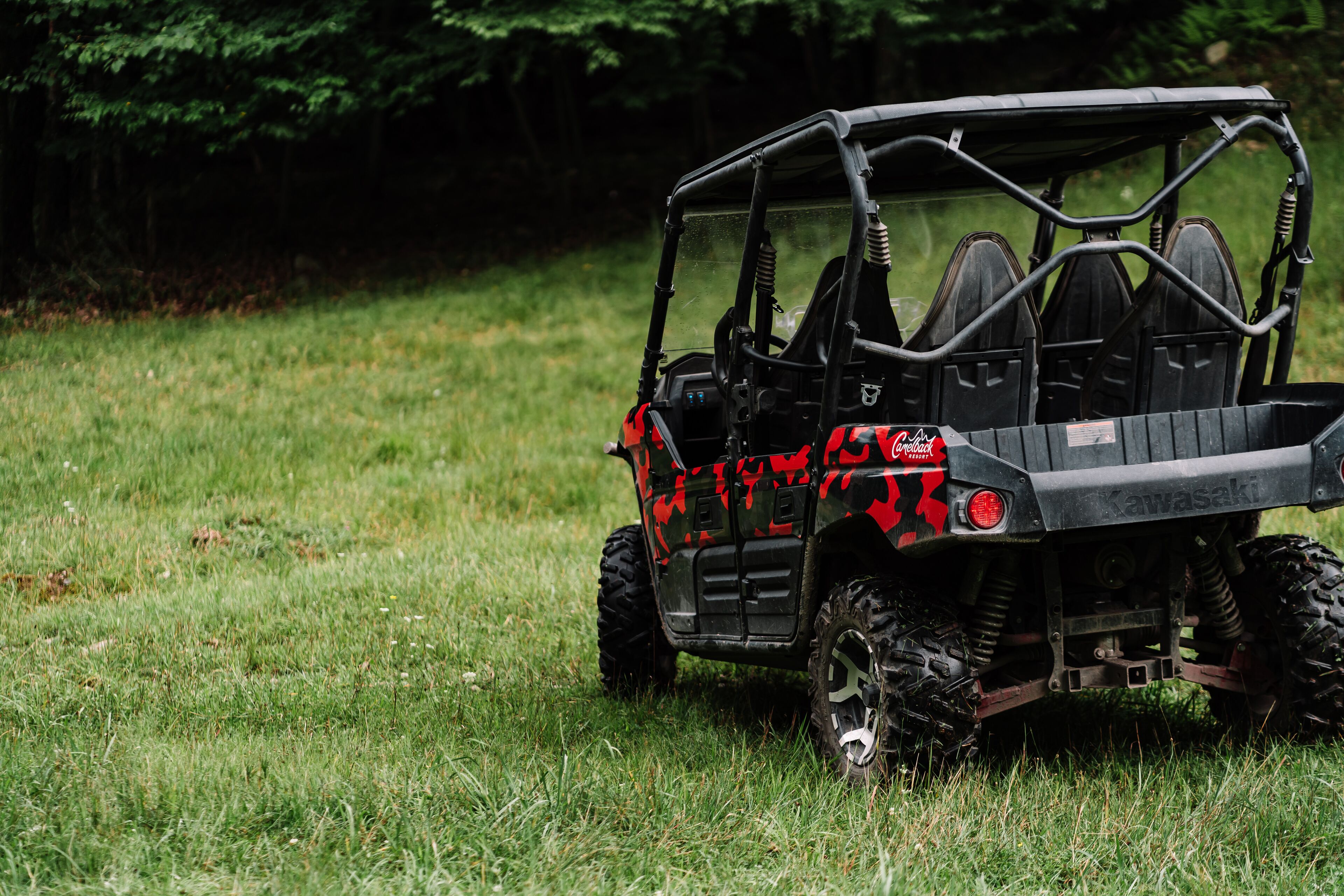 A black and red off-road vehicle parked on grass.