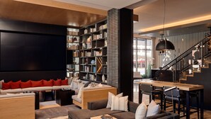 A modern living room with a sofa, coffee table, and bookshelves.