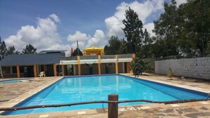 A rectangular swimming pool with a stone deck surrounding it. - Scenic View Hotel & Resort (Nairobi)