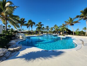 Una piscina al aire libre, una piscina climatizada, sombrillas