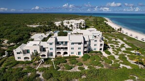 Un gran complejo turístico con varias construcciones, una playa y abundante vegetación.