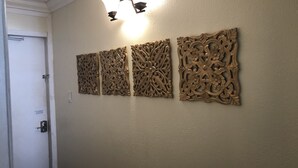 A wall with three ornate wooden panels and a door with a metal handle. - LONG TERM RENTAL ONLY- Oceanfront 1bed/1 bath condo (Daytona Beach Shores)