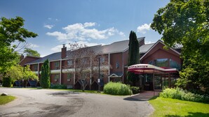 A hotel with a gravel driveway and a covered entrance area. - Mendon Mountainview Lodge (Killington)