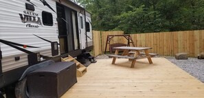 A recreational vehicle with a picnic table and a swing set in a backyard. - Family Time at Hills Hocking @ Pine Creek Villas: Creek Front (Rockbridge)