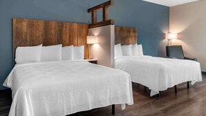 A hotel room with two beds, wooden headboards, white bedding, a nightstand, a lamp, and a chair. - Extended Stay America Premier Suites Tampa Gibsonton Rivervi (Gibsonton)