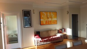A living room with a sofa, a coffee table, and a painting on the wall. - Character home, city close (Inner Kaiti)