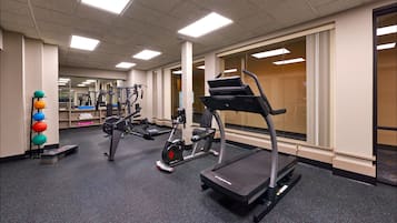 A gym with cardio equipment, weight machines, and a mirror.