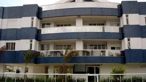 Un edificio de varios pisos con un atrio central, balcones en cada planta y techo plano.
