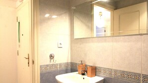 A bathroom with a sink, mirror, and patterned floor tiles. - Avilés-Salinas V. U.T. 612-AS (salinas/castrillon)