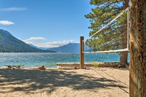 Ein Strand mit einer Holzbank, einem Picknicktisch und einer Seilsperre.