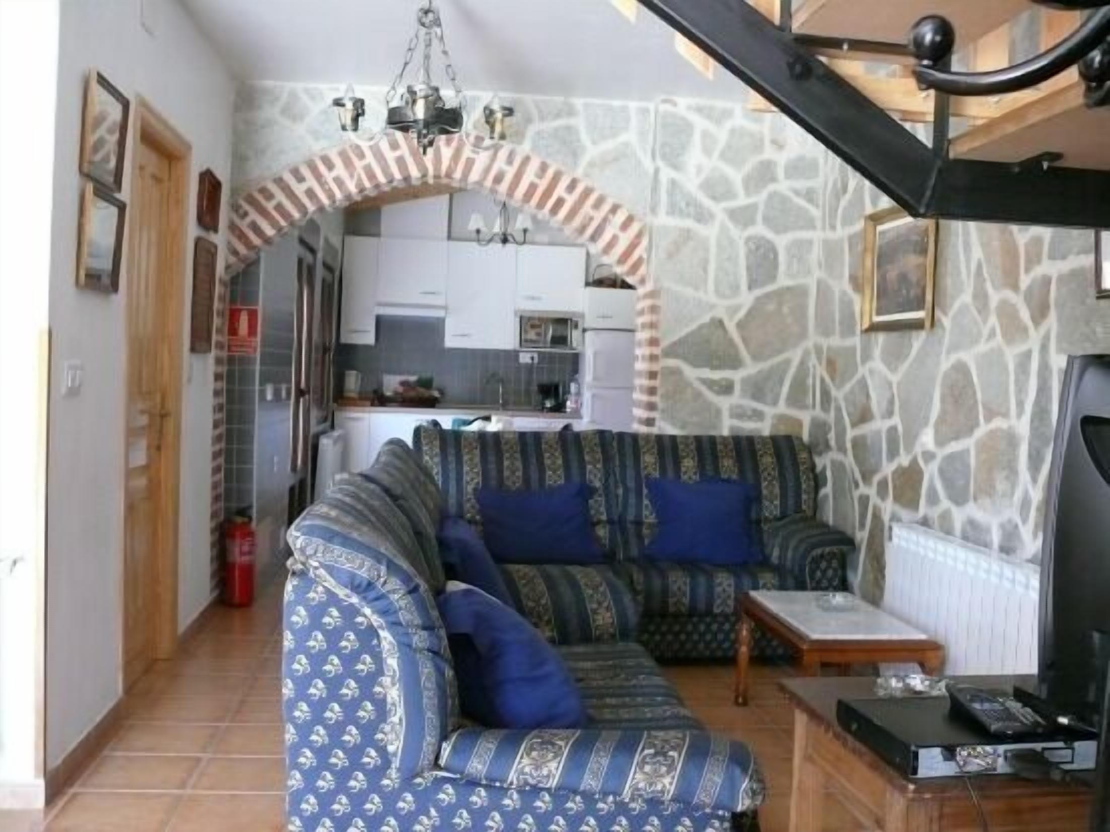 A living room with a sofa set, a coffee table, and a television.