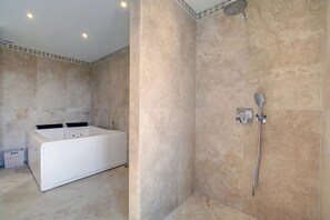 Un baño con bañera y zona de ducha.