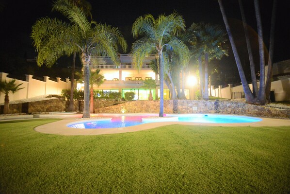 A well-lit hotel with a swimming pool, palm trees, and a stone wall. - Directly on the Golf course.Huge Golf and Spa Mansion 8 min from Puerto Banus (Benahavís)