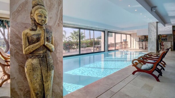 A modern hotel interior with a large indoor pool, a statue, and a bar area. - Directly on the Golf course.Huge Golf and Spa Mansion 8 min from Puerto Banus (Benahavís)