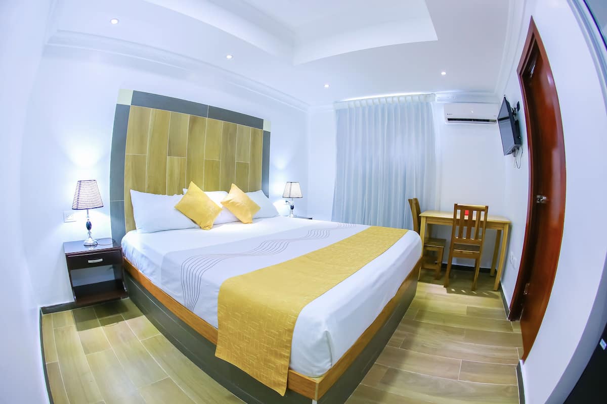 Een hotelkamer met een groot bed, een bureau en een stoel.
