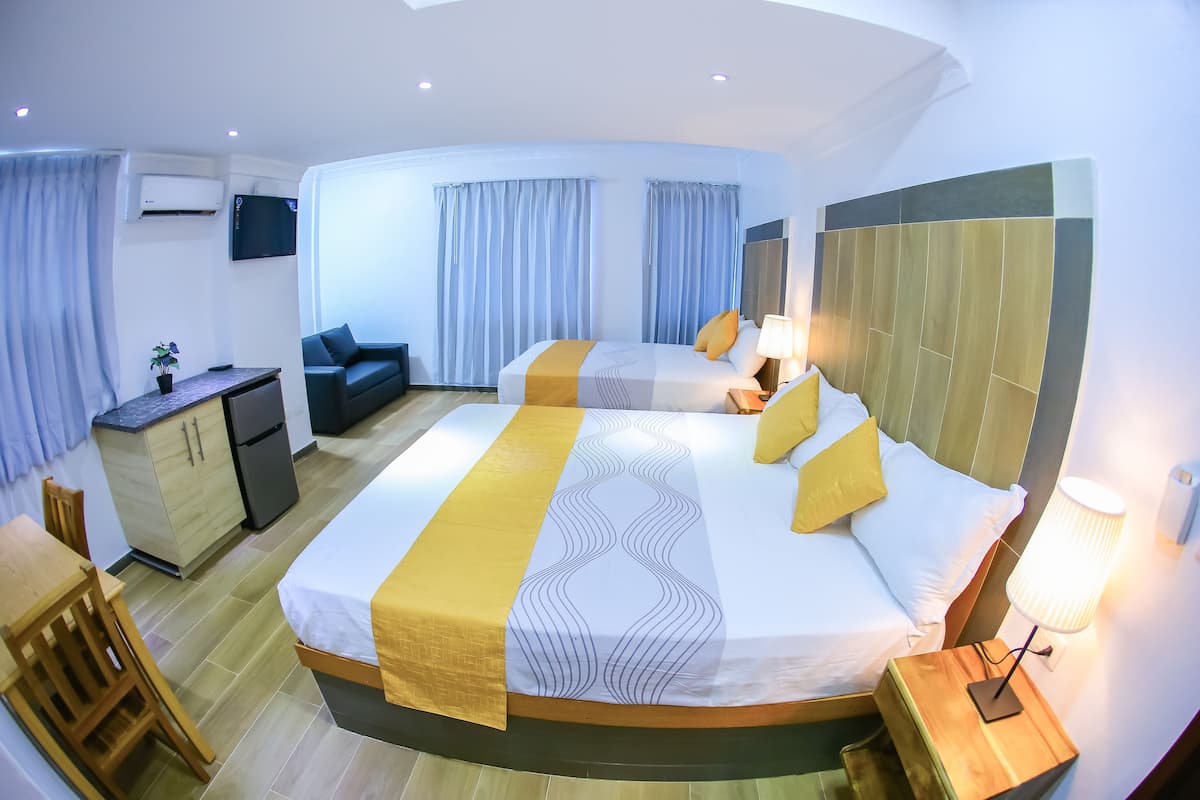 Een hotelkamer met een groot bed, een bureau, een stoel, een televisie en een kledingkast.