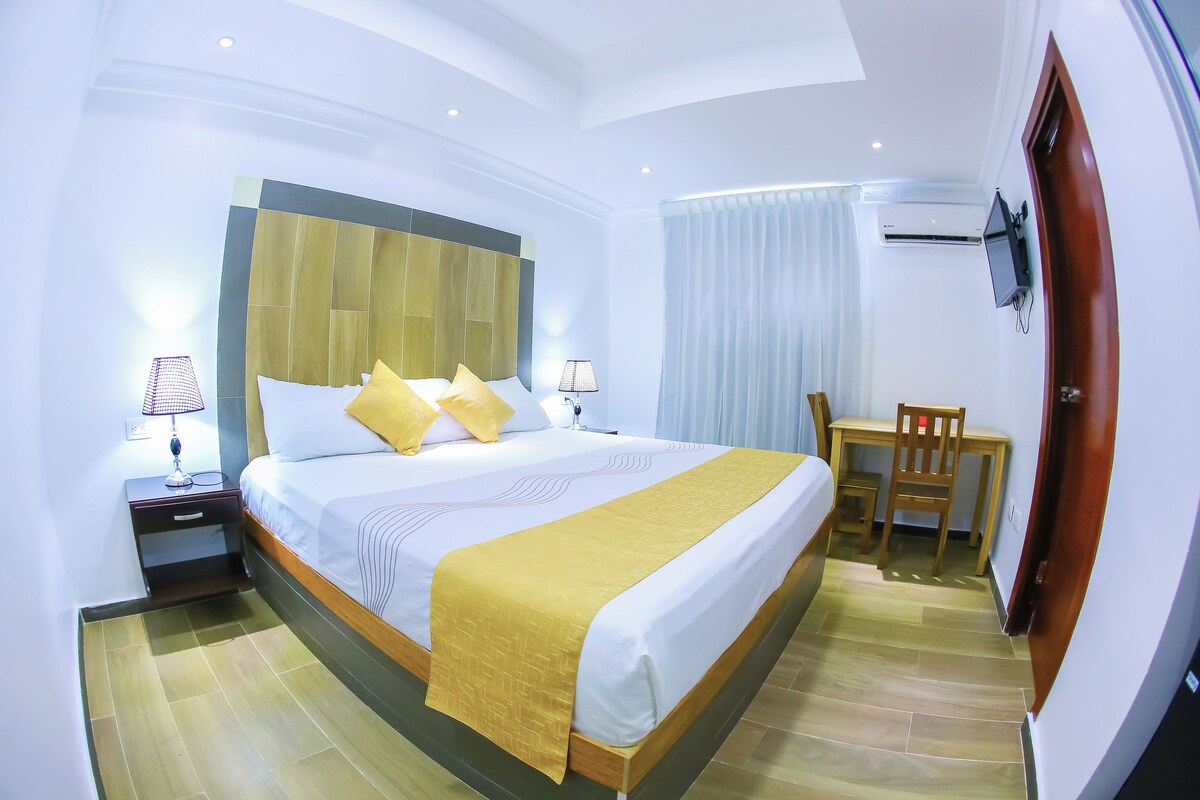 Ein Hotelzimmer mit einem großen Bett, einem Schreibtisch und einem Stuhl.