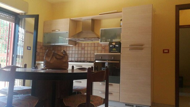 A compact kitchen with a dining area, featuring a stove, oven, and cabinets. - Holiday House in Taormina, Pearl of the Ionian Sea (Trappitello)
