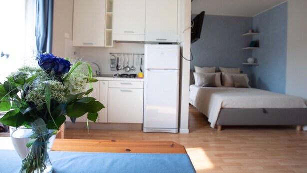 A compact living space with a kitchenette, a bed, and a dining area. - LULLABY HOUSE LAZISE (Lazise)