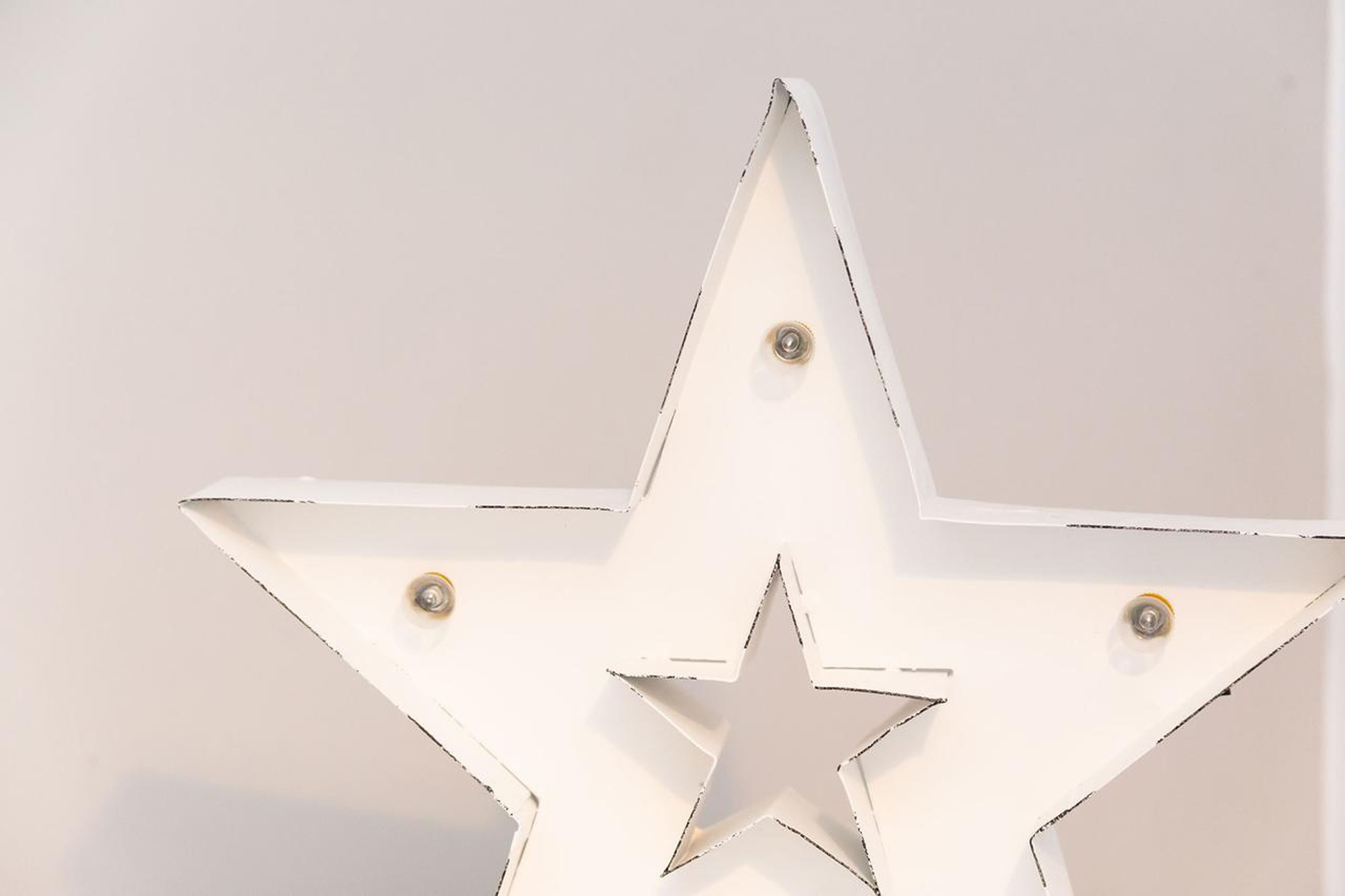 Una decoración en forma de estrella blanca con tornillos.