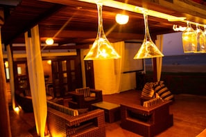 Un ambiente acogedor con mobiliario de mimbre e iluminación colgante.