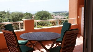 A balcony with a round table and two chairs, overlooking a scenic landscape. - Lovely 2 bedrooms apartment in Torre Soli Nou (San Jaime Mediterráneo)