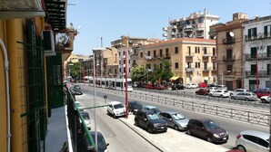 Una calle urbana concurrida con coches, un tranvía y edificios de varios pisos.