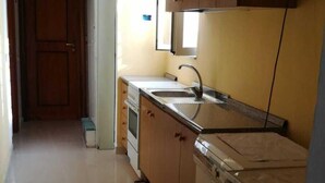 Una cocina equipada con lavadora, lavaplatos y armarios.