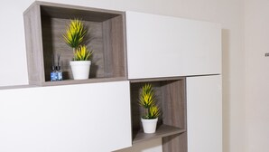 A modern, minimalist room with built-in shelving units and potted plants. - A stone's throw from downtown and the sea modern comfort and the scent of Marsala bread (Marsala)