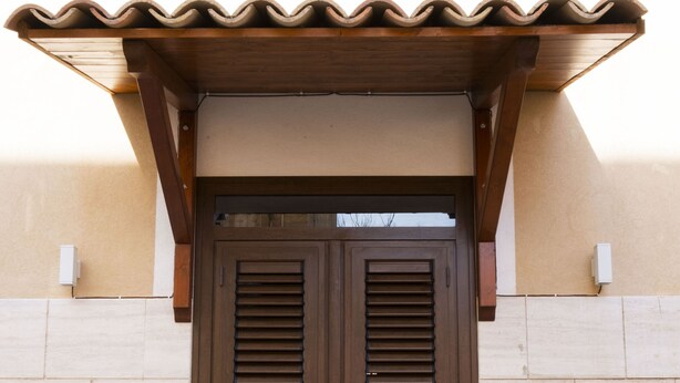 A wooden double door with a brown overhang and a stone base. - A stone's throw from downtown and the sea modern comfort and the scent of Marsala bread (Marsala)