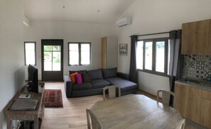 Una sala moderna con un sofá, una mesa de comedor y una zona de cocina.