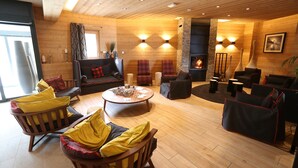 A cozy, well-lit living room with wooden floors, a fireplace, and comfortable seating areas.