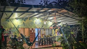 An outdoor seating area with a covered patio, a hammock, and a dining table. - Residencia de la Marina (Boca Chica)