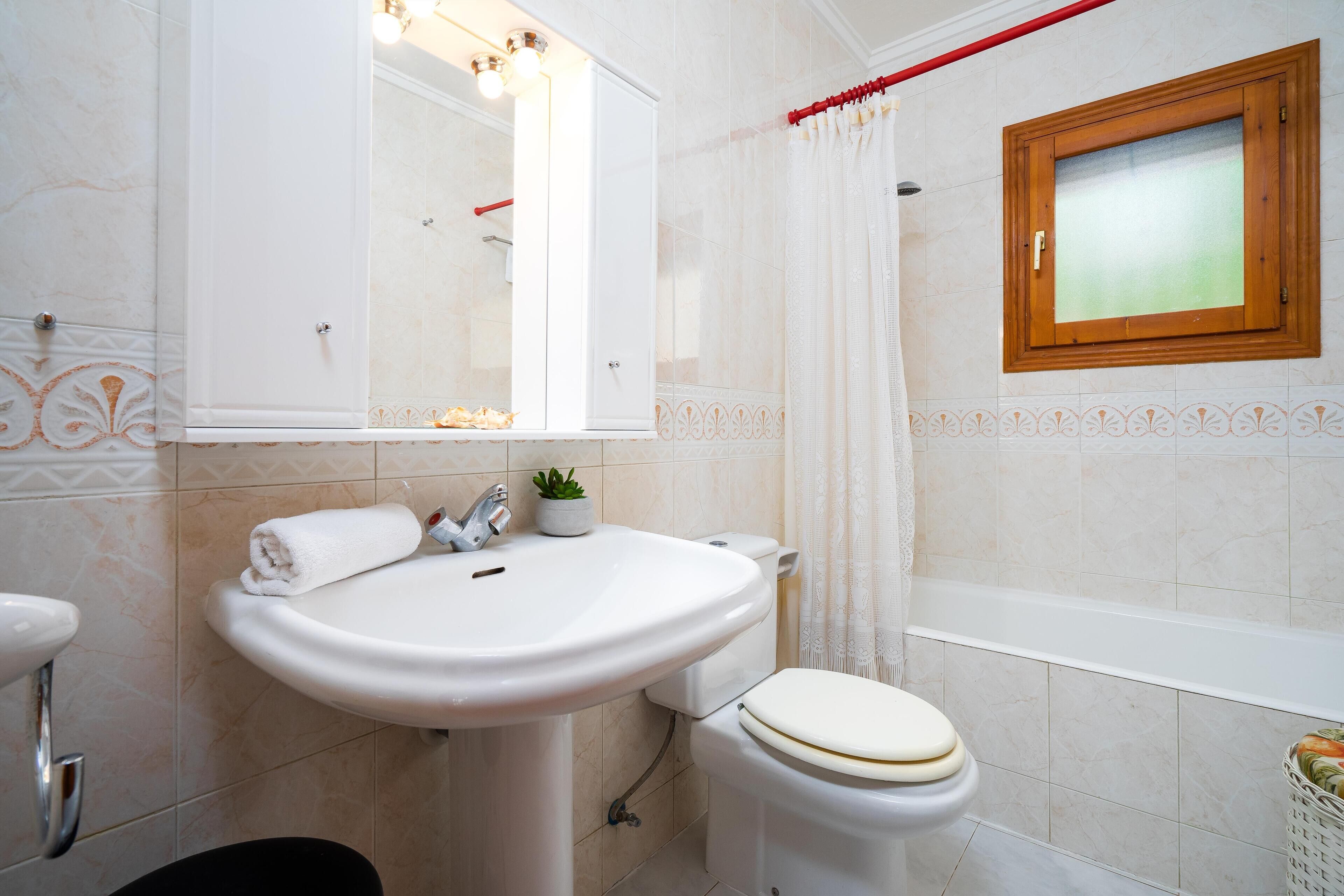 A bathroom with a white sink, toilet, and bathtub.